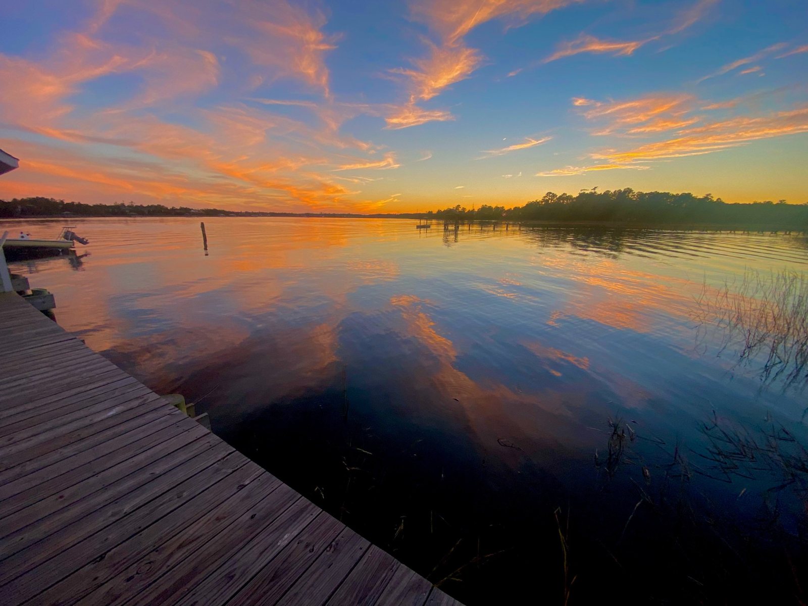 Sunset reflected on the water beside a dock on the Wando River